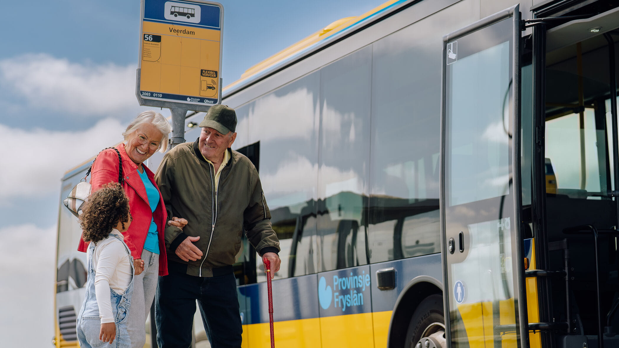Opa, oma en kleinkind staan bij de bushalte voor een bus