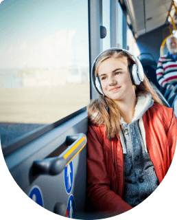 Student reiziger met koptelefoon zit in bus en kijkt uit het raam